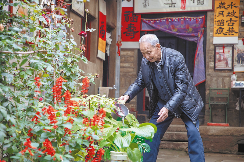 杨甲子老人正在浇花.png